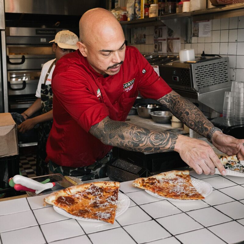 Doughboys chef preparing fresh pizza slices in the kitchen