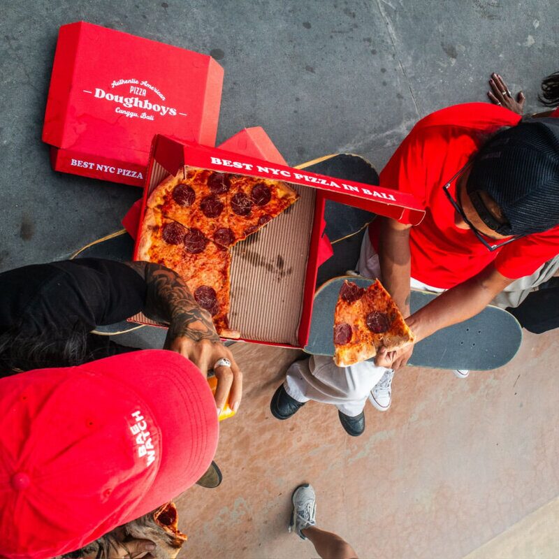 Friends sharing Doughboys pepperoni pizza from above