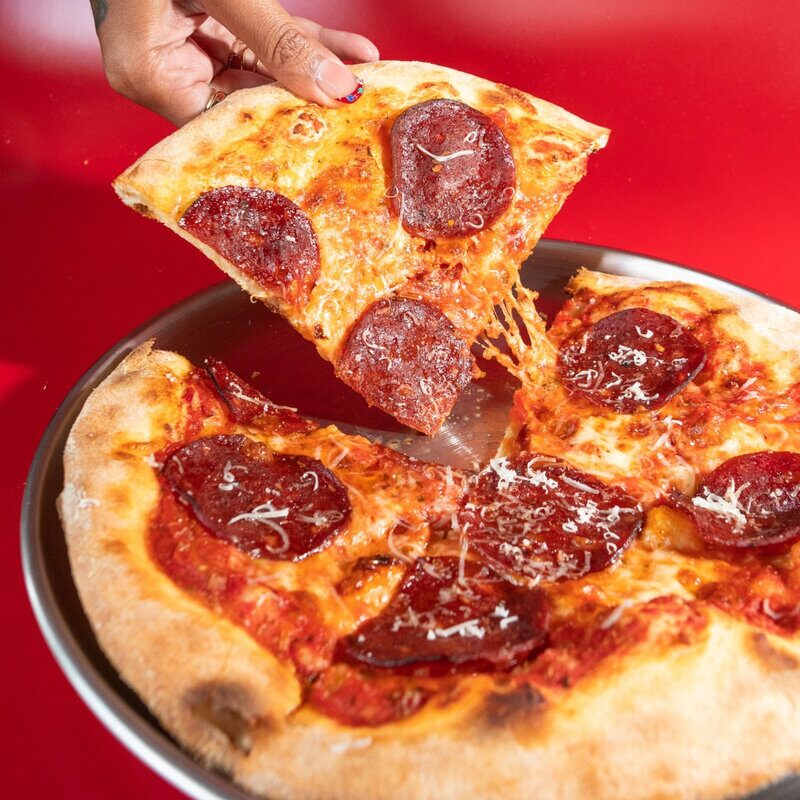 Fresh pepperoni pizza slice with cheese at Doughboys Bali